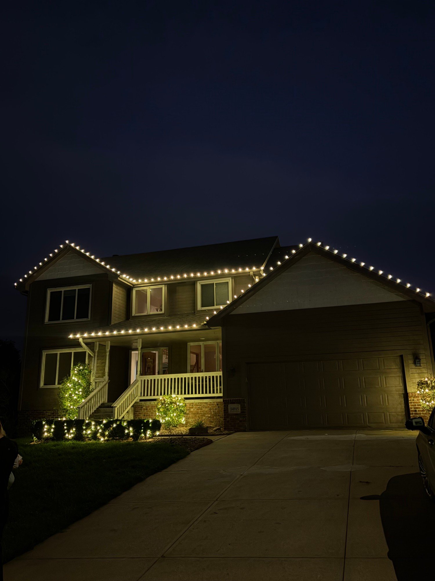 Roofline, porch, hedges and accent trees